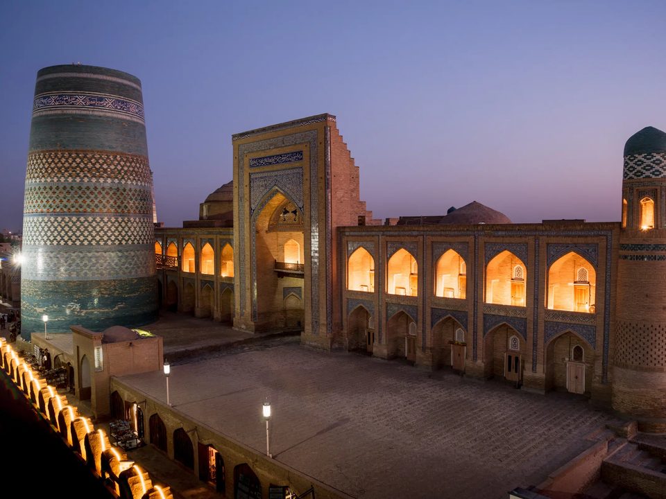 Orient Star Khiva - the Muhammad Amin Khan madrasa and Kalta Minor minaret at dusk